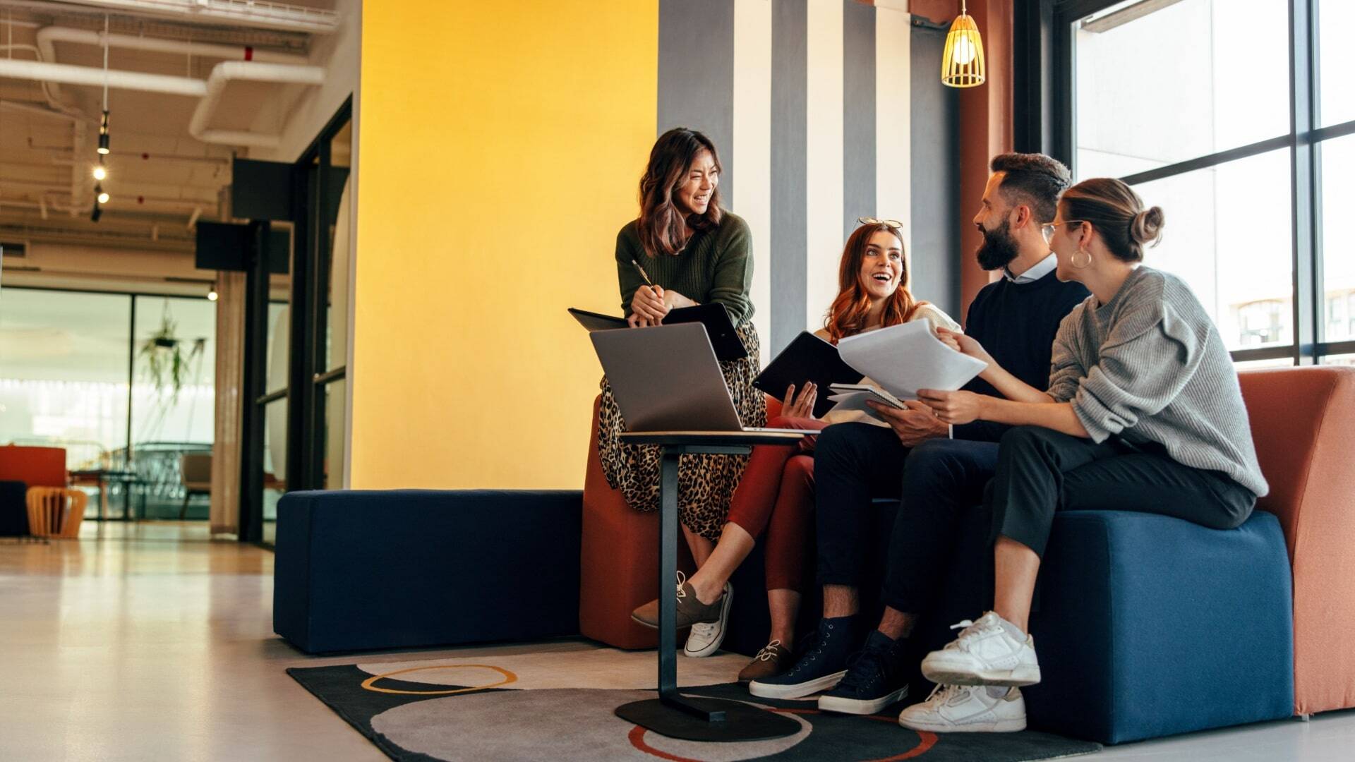 A diverse team collaborates in a modern office, discussing data-driven marketing for nonprofits with a laptop and documents.